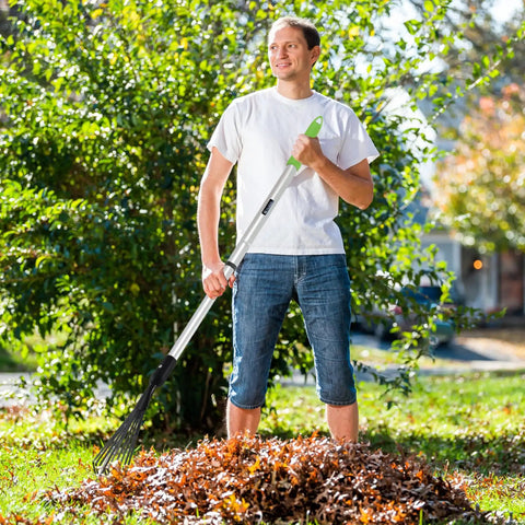Person using adjustable leaf rake and 9 tine cultivator tool with 49 2 inch aluminum and rubber handle in garden