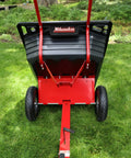 Rock Solid Six Hundred Fifty Pound Poly Dump Cart For Tough Job Site Hauling No Sweat Steering With Three Quarter Inch Pneumatic Tires And Spring Loaded Hitch To Move Yard Debris Easy, viewed from the back.