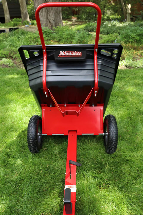 Rock Solid Six Hundred Fifty Pound Poly Dump Cart For Tough Job Site Hauling No Sweat Steering With Three Quarter Inch Pneumatic Tires And Spring Loaded Hitch To Move Yard Debris Easy, viewed from the back.