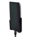 Legit Sturdy Black Smartphone Mount With Heavy Duty Screw Or Tape Options For Vehicles And Home Desk No Sweat Setup And Broad Compatibility For Daily Commutes And Office Use, holding a smartphone with charger.