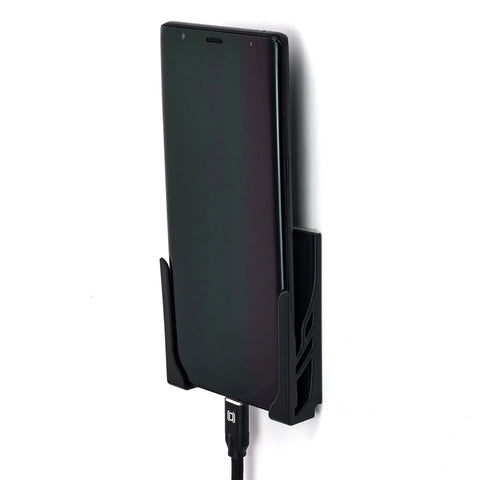 Legit Sturdy Black Smartphone Mount With Heavy Duty Screw Or Tape Options For Vehicles And Home Desk No Sweat Setup And Broad Compatibility For Daily Commutes And Office Use, holding a smartphone with charger.