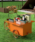 Fly Rideable Food Vending Cart With Canopy And Wheels, Mobile Dessert Display Stand For Festivals, Portable Coffee Cart To Kickstart Your Hustle, Street Smart Vendor Tricycle In Bright Orange positioned on grass with supplies.