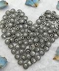Top Shelf Badass Metal Skull Buttons And Screw Back Rivets For Leather Crafting 100 Pc Bulk Set in a heart shape arrangement.