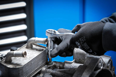 Hands using the Master Grade 150 Piece Socket Set With Quarter Inch And Half Inch Drives featuring a super lock socket on an engine.