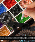 Hand using Piercing Ball Grabber Tool For Changing Jewelry Stainless Steel Diamond Claw Tweezers next to assorted beads.