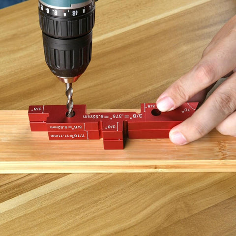 Close-up of Aluminum Setup Blocks 14 Piece Set With Case For Woodworking in use with a drill on wooden surface.