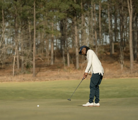 Golfer using Infinite Zero Torque 606 Putter Right Hand 35 Inch With Double Milled Face on green in wooded setting.