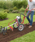 Man using Rugged 4HP 63cc Gas Powered Garden Tiller With Wheels 4 Stroke Rototiller for plowing and tilling garden soil