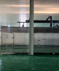 High Capacity Industrial IQF Tunnel Freezer Built Different Stainless Steel Conveyor Belt Blast Freezing System For Quick Freezing Meat Seafood Produce Factory Plant Operations side view in a production facility.