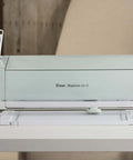 Front view of mint Cricut Explore Air 2 cutting machine with white base and cutting mat