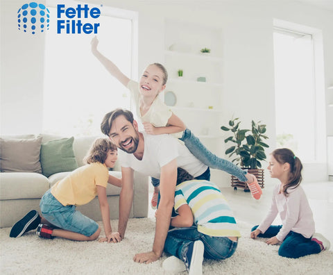 Happy family playing in living room with 3-In-1 Replacement True HEPA Filters For Home Air Purifiers Compatible With Popular Purifier Models nearby.