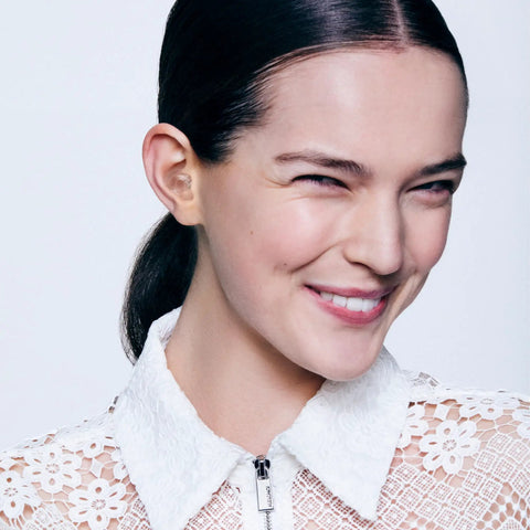 Smiling person wearing Engage Conversation Earplugs for Clear Speech and Light Noise Reduction at Social Gatherings.