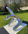 Rad Chrome Paint Pint Kit Featuring 2K Basecoat And 1K Topcoat delivers a shiny chrome hand sculpture in a garden setting.