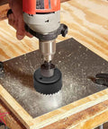 Using 11 Piece Hole Saw Kit With Mandrel And Hex Key, Three Quarters To Two And A Half Inch Cutters on wood board