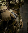 Original Tactical Glove With High Performance Anti Slip Grip For Real World Job Sites And Touchscreen Ready Safety Gear Impact Resistant Protection Medium Fit In Coyote Brown All Day Comfort And Flexible Cuff, highlighted on soldier's hand holding equipment.