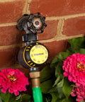 Mechanical Outdoor Timer For Irrigation With Auto Shutoff After Set Run Time, mounted on brick wall with garden flowers