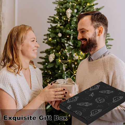 Couple exchanging gifts in front of decorated Christmas tree with exquisite gift box visible