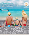 Family sitting on beach on Outdoor Rug For All Weather Use Waterproof Plastic Straw Style Mat Large 5x8 Area Rug For Outdoor Living Yard Vibes Patio Deck Backyard RV Beach Balcony Porch White And Gray