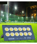 JUDYSSY Ultrathin Led Flood Light 600W illuminated soccer court at night with bright LED spots on a grassy field.