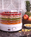 Straight Up Five Tray Food Dehydrator Machine With Adjustable Temperature Dial Horizontal Heat Flow For Preparing Homemade Jerky Fresh Herbs Ripe Fruit Crunchy Veggies Zero Additives Bpa Free White displaying dehydrated fruits.
