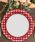 48 Pack Red And White Checkered Disposable Paper Plates For Backyard Kickbacks on a wooden table with flowers and cutlery.