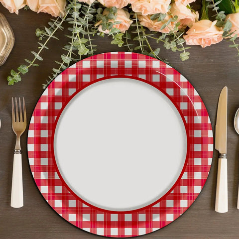 48 Pack Red And White Checkered Disposable Paper Plates For Backyard Kickbacks on a wooden table with flowers and cutlery.