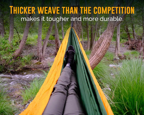 Person relaxing in Cozy Two Person Camping Hammock With Bug Net And Rain Fly Lightweight Double Parachute Nylon in forest.