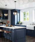 Edwardian Widespread Bridge Kitchen Faucet With Side Spray In Pure Unlacquered Brass above a stylish blue kitchen island.