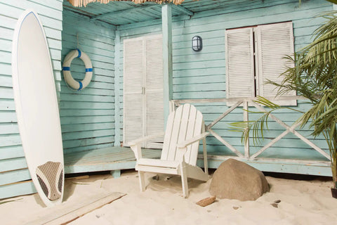 Outdoor 10 Point 6 Inch Oval LED Nautical Bulkhead Light on blue beach cabin wall with surfboard and white chair