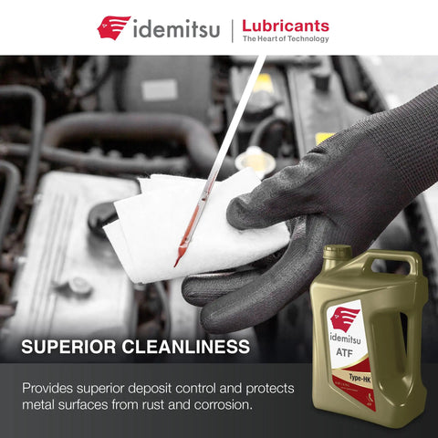 Idemitsu ATF Type HK fluid bottle beside mechanic checking transmission fluid with gloved hand on car engine