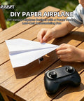 Child playing with Dope RC Paper Airplane Kit With Gyro Stabilizer And Dual Propellers on a wooden table