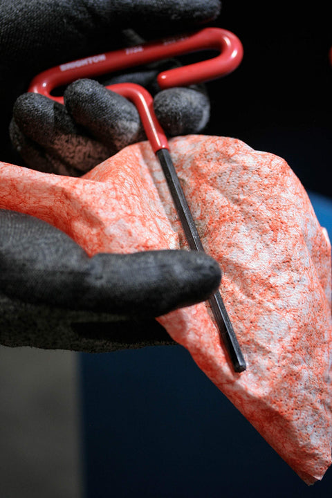 Person using heavy duty hand and tool wipes to clean tool; Grease Busting Heavy Duty Hand And Tool Wipes For Degreasing Hands And Work Surfaces.