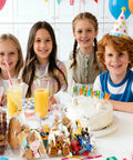 Children at a birthday party with Clear Cellophane Treat Bags 200 Pack 6X10 Inch With Gold Twist Ties filled with snacks.