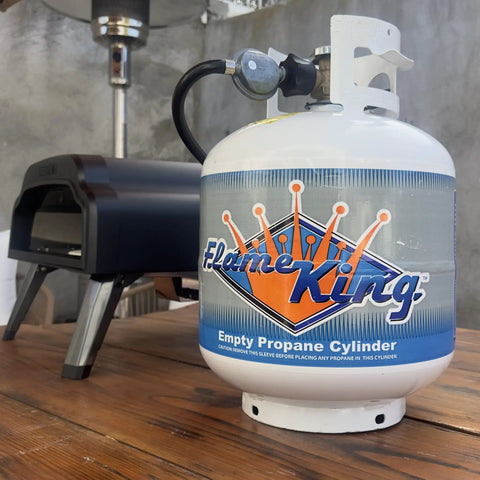 20 Pound Steel Propane Tank With Type 1 Overflow Protection Valve For Grills And BBQs DOT Approved Cylinder on wooden table.