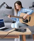Woman playing guitar with USB Audio Interface For Recording Music With 2 Channel Mic Preamps 48V Phantom Power Plug And Play