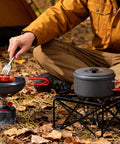 Durable Camping Cookware Set With Portable Pots And Pans For Outdoor Backpacking cooking sausage over campfire in pan