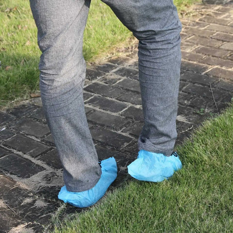 Person wearing Heavy Duty Disposable Shoe Covers For Home And Work Jobsites Waterproof Booties With Elastic Band walking on a path