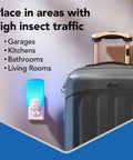 Flying Insect Light Trap Starter Kit With Easy Plug In Device And Replacement Cartridge Kid Friendly And Pet Safe Chemical Free Home Insect Control Light Powered Attraction For Any Room plugged in a wall socket near a suitcase in a hallway.