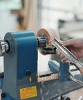 Wood lathe in action with wood being turned. Focus on 3 Inch Steel Wood Lathe Face Plate With 8 Screw Holes For Easy Mounting.