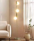 Nola Mid Century Modern 3 Globe Floor Lamp For Living Room And Office, gold LED light next to a beige sofa and plant