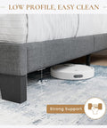 Full Platform Bed Frame With Upholstered Fabric Headboard In Grey Featuring Dense Foam Padding And Breathable Polyester For Super Comfy Nights and Straight Up Quality Bedding Setup, showcasing low profile design with cleaning robot underneath.