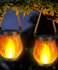 Hanging 2 Pack Gen2 Solar Lantern Lights with USB C, showing ultra-real flame glow and warm white light at night.