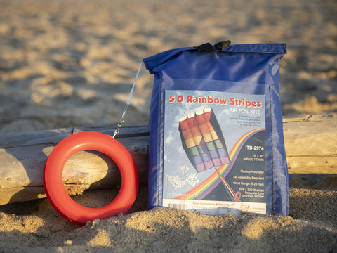Rainbow Stripes 5.0 Parafoil Kite For All Ages packaged and ready, frameless, single-line, on sandy beach background