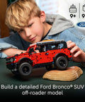 Child assembling Ford Bronco Technic Off Road SUV Building Kit For Kids 9 And Up with realistic suspension, indoors.