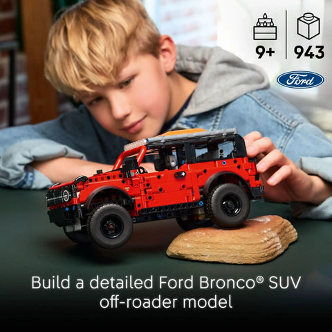 Child assembling Ford Bronco Technic Off Road SUV Building Kit For Kids 9 And Up with realistic suspension, indoors.