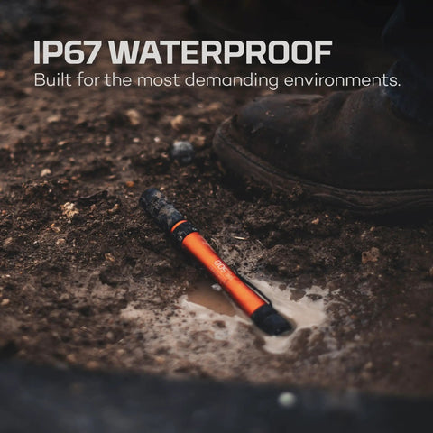PL500 Penlight 500 Lumens lying in muddy water, showcasing IP67 waterproof feature, with foot partially visible, suitable for camping and EDC.