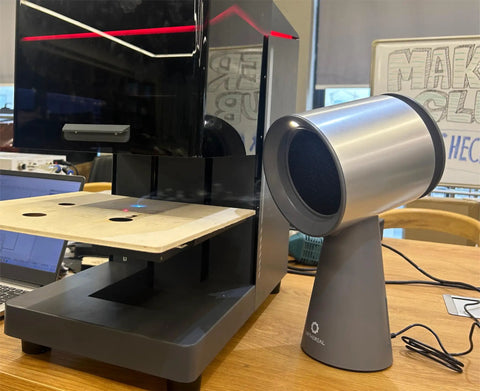 Heavy Duty Solder Fume Extractor Fan With Badass Suction And Slick Design For Desktop DIY Stations next to a workspace.