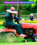 Lawn tractor operator driving a red riding mower across a grassy field.