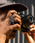 Person using Micro Clutch I Plate Hand Strap For Mirrorless Cameras With Low Profile Finger Loop Battery Access ARCA Compatible Baseplate