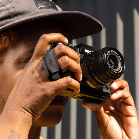 Person using Micro Clutch I Plate Hand Strap For Mirrorless Cameras With Low Profile Finger Loop Battery Access ARCA Compatible Baseplate